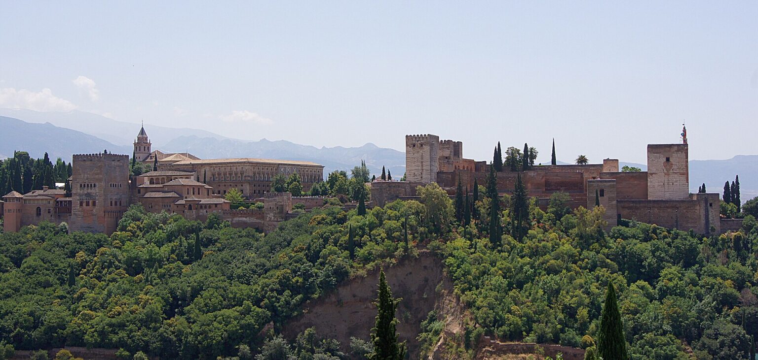 The Alhambra on its wooded hill above Granada, seen from the Mirador de San Nicolás in the Albaicín, a highlight of Andalucía tours | AndaluciaTours