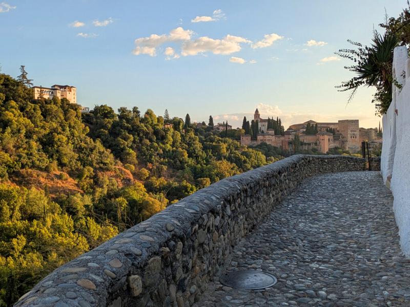 Cobblestone path, distant buildings, lush greenery – Granada, Andalucía | Andaluciatours